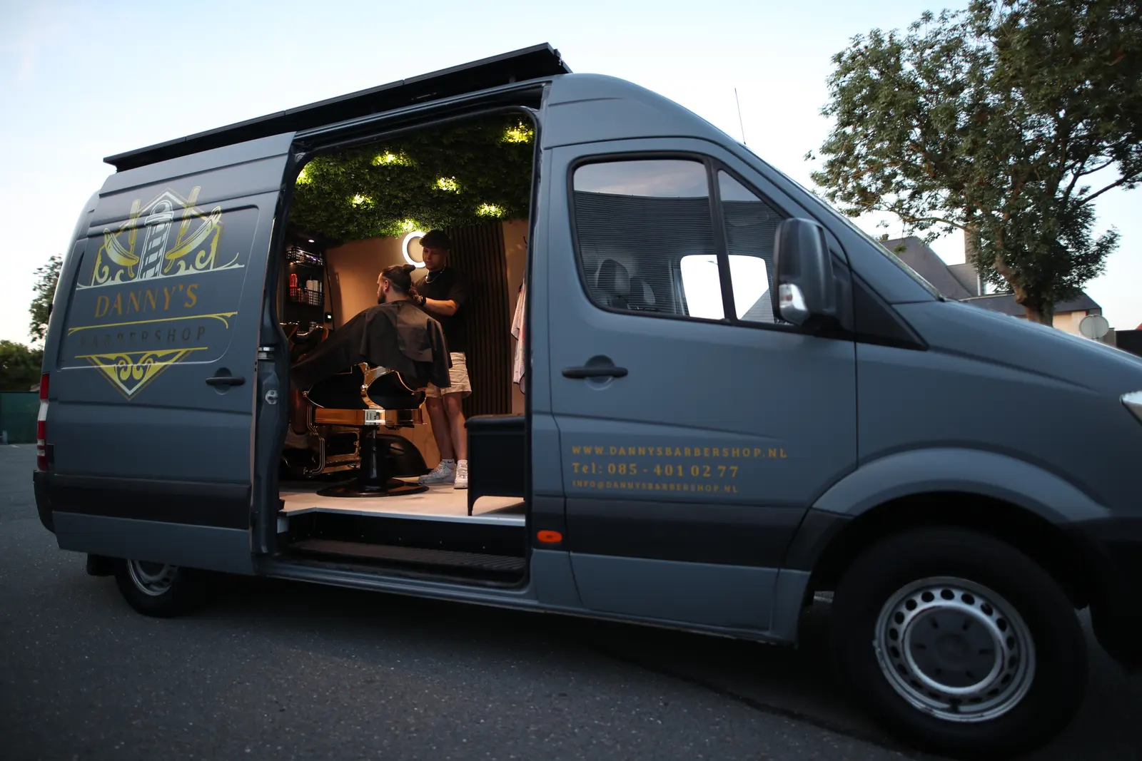 Danny's Barbershop kapperbus met geopende schuifdeur, klaar voor een knipbeurt in Boskoop